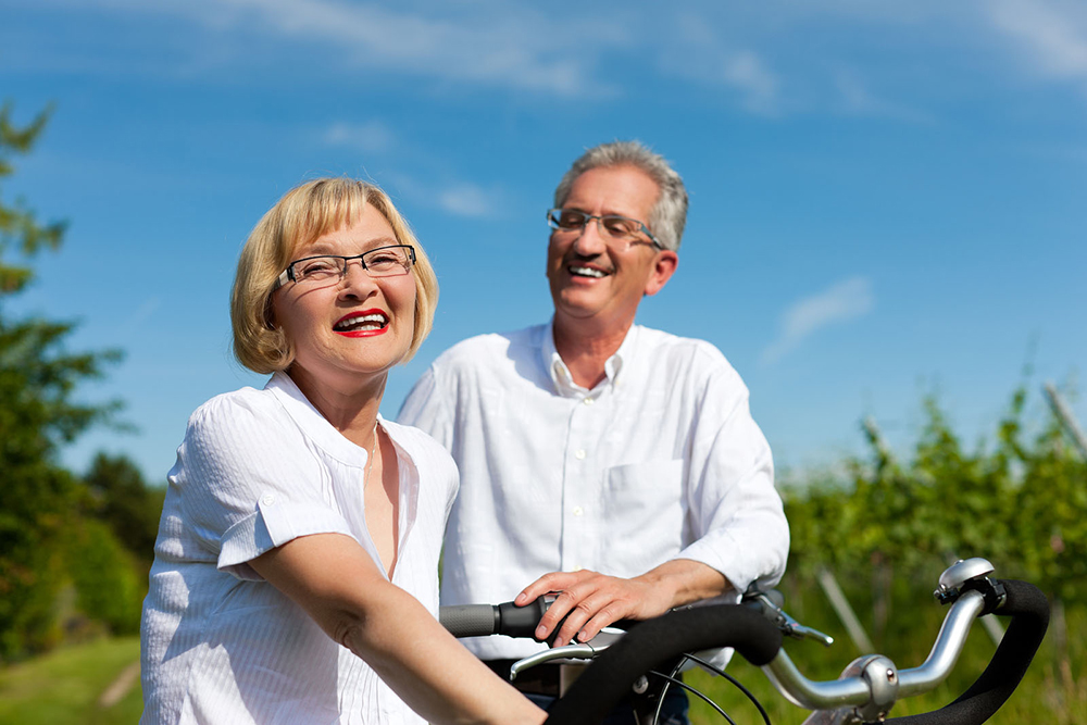 Elderly Couple enjoy the sunny day on two bikes
