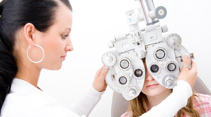 woman giving child an eye health exam and a site test in Maple Ridge