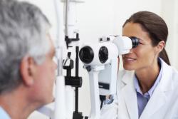woman doctor giving man an eye exam