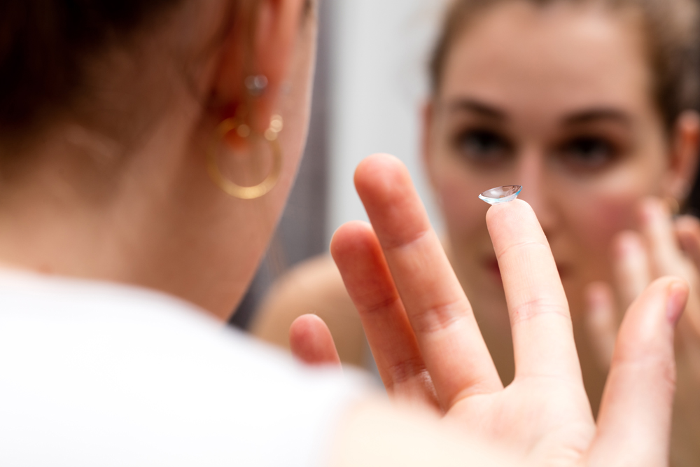 woman holding contact lens