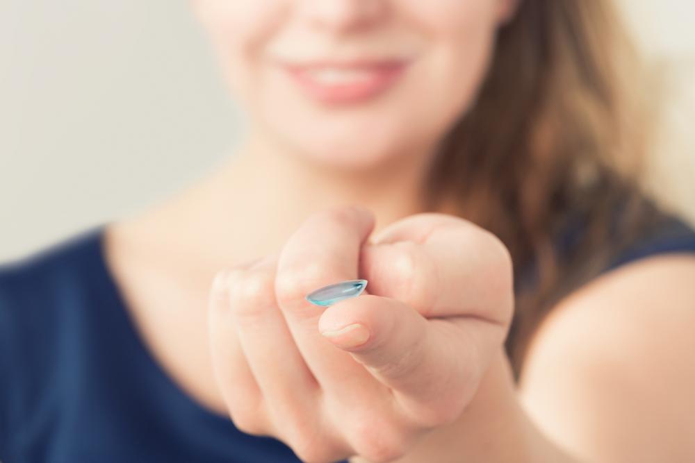 Woman holding contact lens at Arlington Optometrist